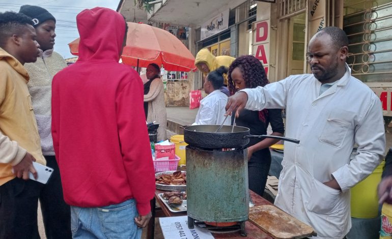 Street food vendor calling the shots from roasted chicken sales