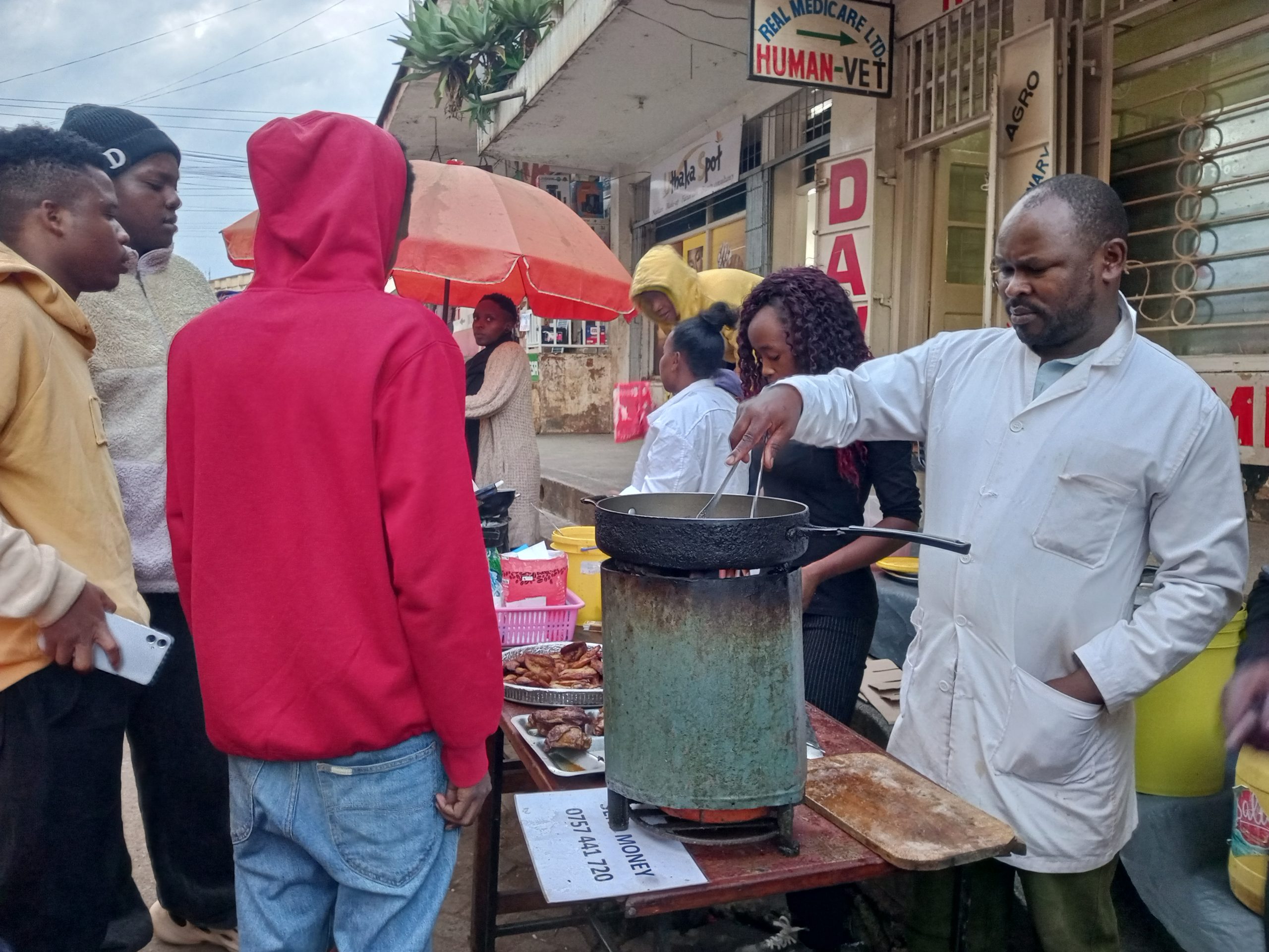 Street food vendor calling the shots from roasted chicken sales